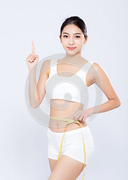 Beautiful portrait asian woman diet and slim with measuring waist for weight finger pointing something isolated