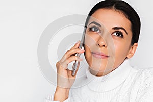 Beautiful portrait of attractive young dream woman with mobile phone with pretty toothy smile, on the white background.