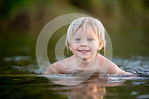 Beautiful portrait of child in lake, kid playing