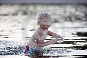 Beautiful portrait of children in lake, kids playing in the water on sunset, summer