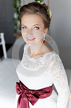 Beautiful portrait of a gentle cute happy bride in a white dress with a bright little colored bouquet