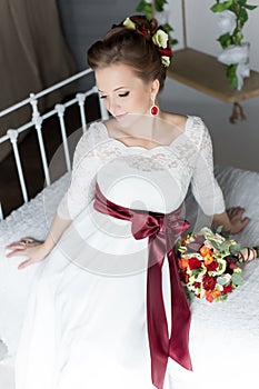 Beautiful portrait of a gentle cute happy bride in a white dress with a bright little colored bouquet