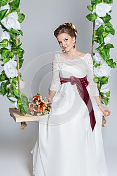 Beautiful portrait of a gentle cute happy bride in a white dress with a bright little colored bouquet