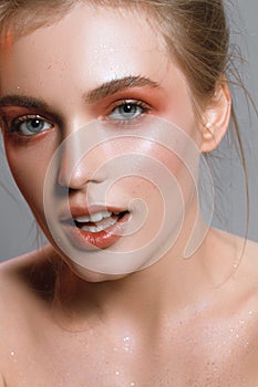 Beautiful portrait of a girl with wet make-up and shiny skin