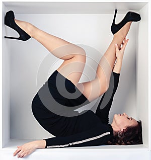 Beautiful portrait of a girl in a white cube sitting