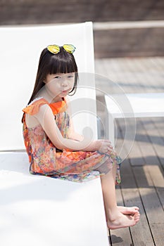 Beautiful portrait little girl asian of a smiling sitting at swimming pool