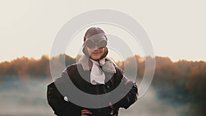 Beautiful portrait of little girl in old pilot flight jacket and glasses on sunset, concept of courage slow motion.