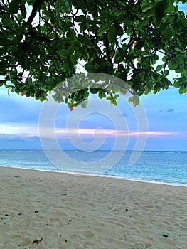 Beautiful portrait picture of a peaceful and empty beach in Bali, Indonesia in the summer during the evening sunset.