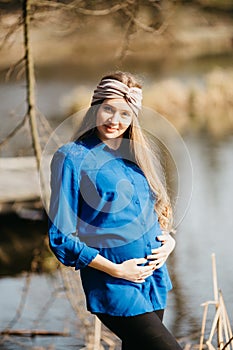 Beautiful portrait of a pregnant woman in the forest