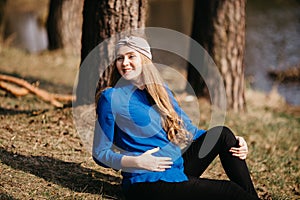 Beautiful portrait of a pregnant woman in the forest