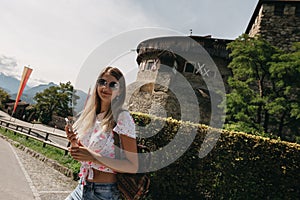 Beautiful portrait of a smiling young girl in stylish glasses.Traveling girl with a backpack on his shoulders.Woman