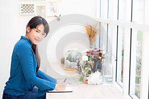 Beautiful portrait young asia woman writer writing on notebook or diary with happy, lifestyle of asian girl is student