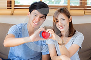 Beautiful portrait young asian couple gesture holding heart shape together, man and woman cheerful smiling