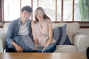 Beautiful portrait young asian couple relax and satisfied together in living room at home