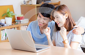 Beautiful portrait young asian couple working laptop with smile and happy sitting in bedroom