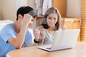 Beautiful portrait young asian couple working laptop with smile and happy sitting in bedroom, man and woman using notebook