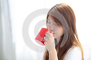 Beautiful of portrait young asian woman with drink acup of coffee standing curtain window background