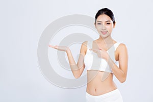 Beautiful portrait young asian woman fit smiling gesture showing presenting something empty on hand isolated