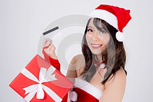 Beautiful portrait young asian woman happy holding credit card and red gift box in Christmas holiday isolated