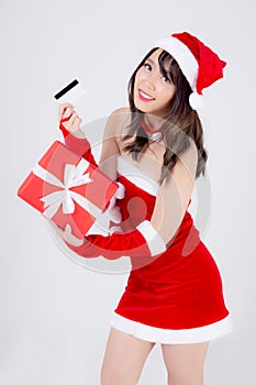 Beautiful portrait young asian woman happy holding credit card and red gift box in Christmas holiday isolated