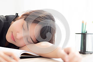 Beautiful portrait young asian woman learning exam or homework and sleep with tired and stress.