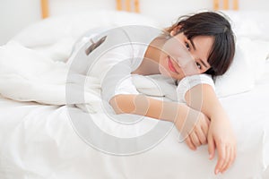 Beautiful portrait young asian woman lying and smile while wake up with sunrise at morning, girl with happy and fun