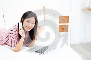 Beautiful of portrait young asian woman lying users credit card