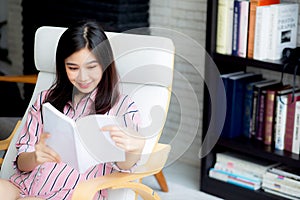 Beautiful of portrait young asian woman relax sitting reading book in living room