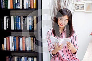 Beautiful of portrait young asian woman relax sitting reading book in living room at home, girl study literature.