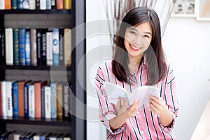 Beautiful of portrait young asian woman relax sitting reading book in living room at home