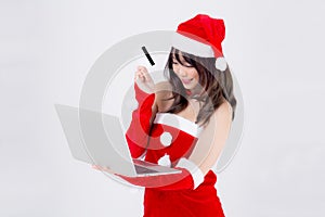 Beautiful portrait young asian woman in santa holding credit card and laptop computer for shopping online in Christmas