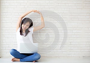 Beautiful portrait young asian woman sitting with laptop stretch