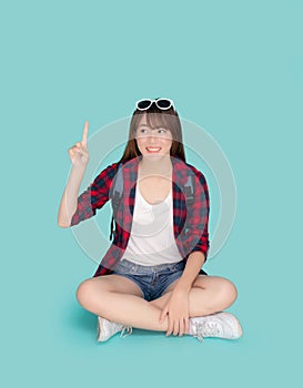 Beautiful portrait young asian woman sitting smile confident and excited pointing something summer holiday isolated