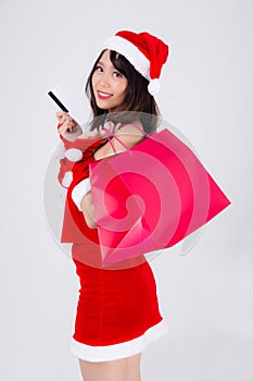 Beautiful portrait young asian woman smiling holding credit card and shopping paper bag with excited isolated on white background