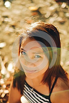 Beautiful portrait of young Asian woman smiling, with nice sunflair