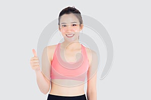 Beautiful portrait young asian woman in sport clothes with satisfied and confident gesture thumbs up isolated