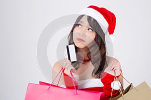 Beautiful portrait young asian woman thinking and holding credit card and shopping bag with excited isolated