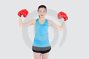 Beautiful portrait young asian woman wearing red boxing gloves flexing with strength and strength isolated