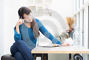 Beautiful portrait young asian woman writer smiling thinking idea and writing on notebook or diary with happy