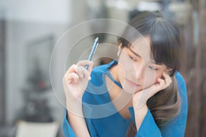 Beautiful portrait young asian woman writer smiling thinking idea and writing on notebook or diary with happy, lifestyle of asian