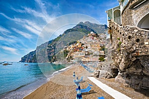 Beautiful Positano with colorful architecture on hills leading down to coast, comfortable beaches and azure sea on Amalfi Coast in