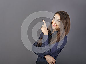 Beautiful positive business happy woman in blue shirt showing the finger up on empty copy space grey background. Closeup