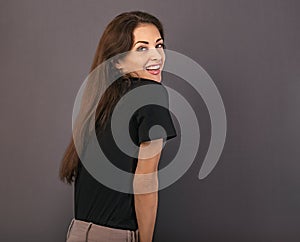 Beautiful positive laughing business happy woman in black t-shirt  looking in camera on empty copy space grey background. Closeup