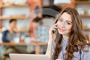 Beautiful positive young woman talking on cellphone