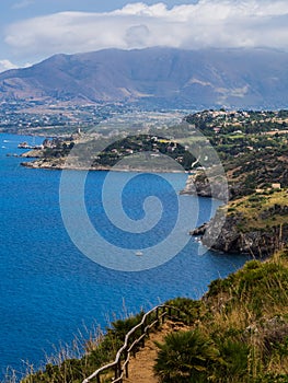 Beautiful postcard view of the Sicilian rocky coast in Italy, walking on a dirt path in the Gypsy Reserve