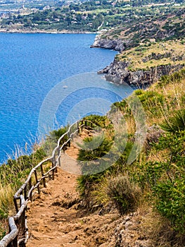Beautiful postcard view of the Sicilian rocky coast in Italy, walking on a dirt path in the Gypsy Reserve photo