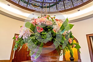 Beautiful potted colorful flowers with leaves under stained glass dome roof