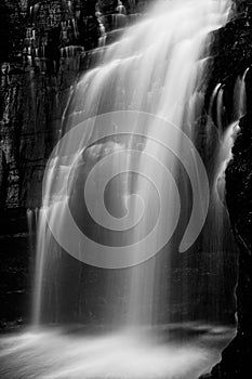 Powerful waterfall flowing down cliff ledge