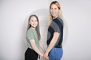 Beautiful pre teen girl with mother on studio white background