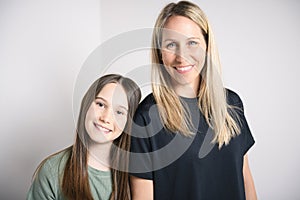 Beautiful pre teen girl with mother on studio white background